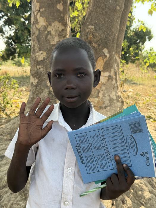 A boy proudly showing his new exercise books