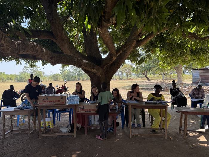 Foundation team registering families under a tree