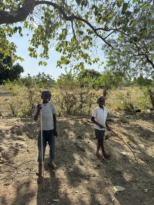 Two boys playing outside near their village