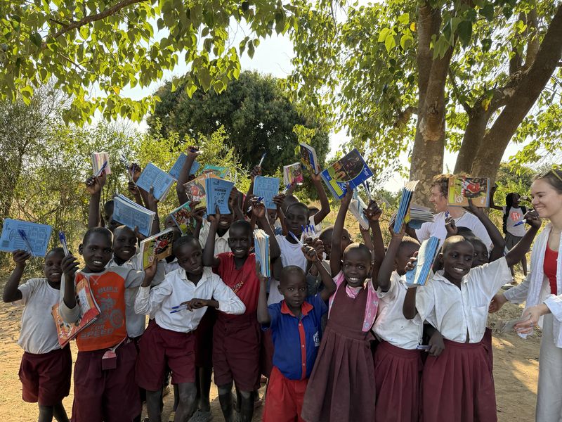 Children holding up their new notebooks and pens